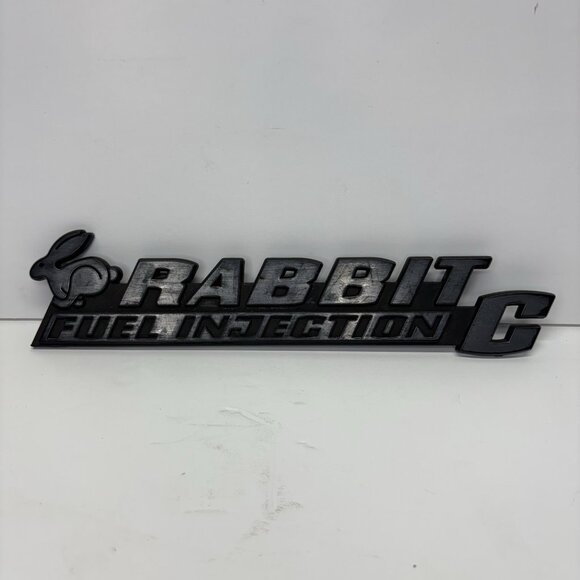 75 76 77 78 79 80 81 82 83 84 VW RABBIT C REAR EMBLEM LOGO BADGE USED OEM A24234 - Picture 1 of 5